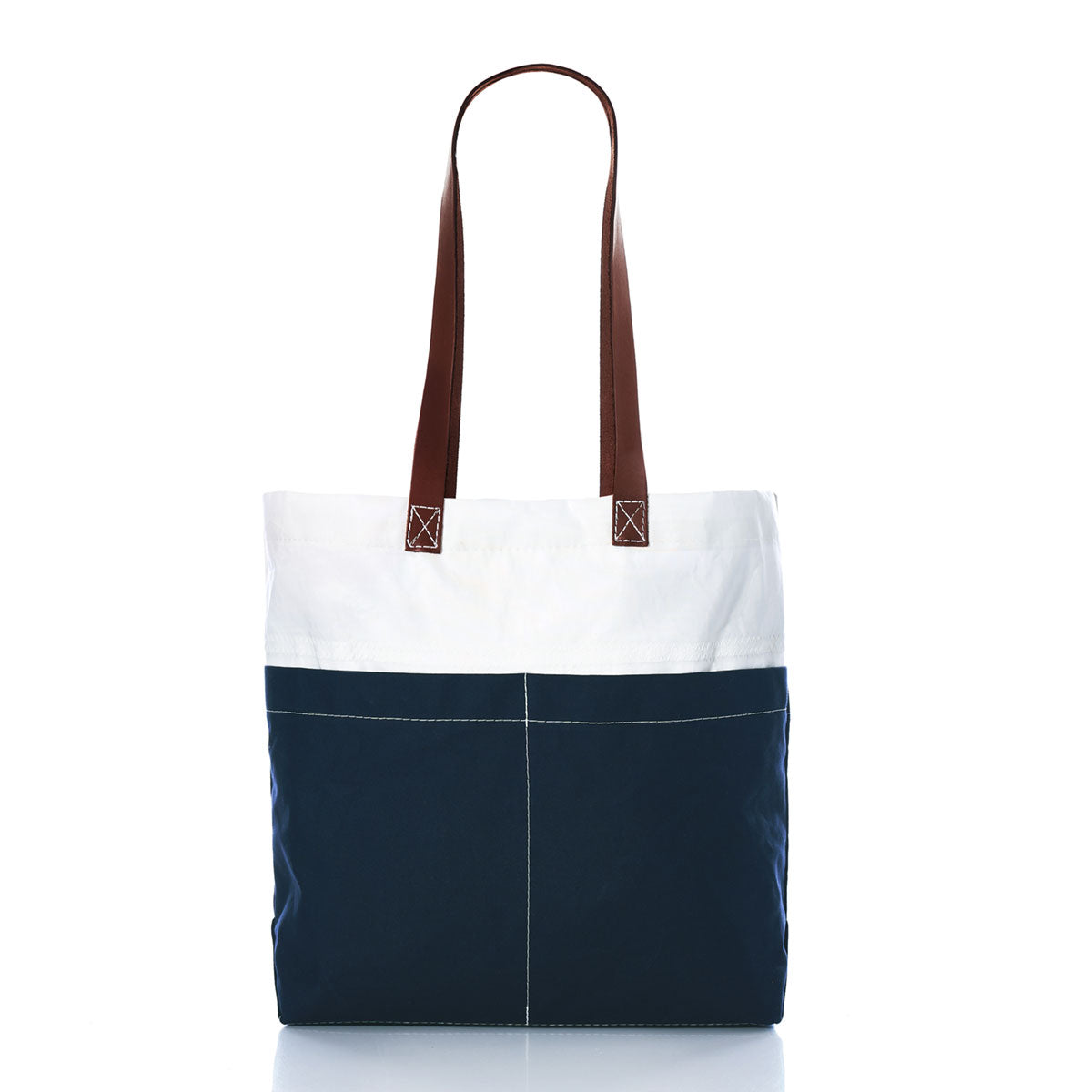The Sea Bags Navy Chebeague Market Tote showcases a two-tone design with a white upper section and a navy blue lower section, complemented by brown leather handles and white front stitching. Crafted from recycled sails, it is presented against a white background. by Sea Bags