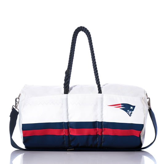 Introducing the Sea Bags New England Patriots Duffel—a unique eco-friendly bag crafted from recycled white and navy sail cloth, featuring striking red stripes, rope handles, an adjustable shoulder strap, and a bold Patriots logo on the side. Perfect for fans looking to stand out with a sustainable alternative to classic NFL duffels. by Sea Bags