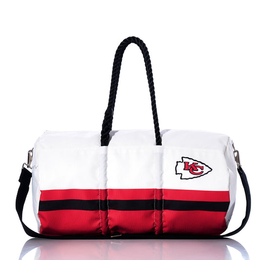 Introducing the Sea Bags Kansas City Chiefs Duffel—a white, red, and black gym bag featuring a prominent team logo, sturdy black handles, and a detachable shoulder strap. Officially NFL licensed and set against a clean white background, this bag effortlessly blends style and functionality—making it the perfect choice for Chiefs fans on the move. by Sea Bags