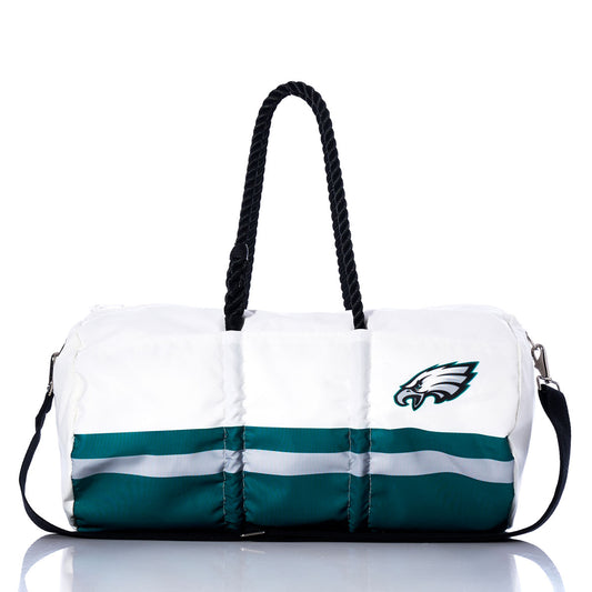 The Sea Bags Philadelphia Eagles Duffel is a white and green bag crafted from recycled sail cloth, featuring black handles, a detachable black shoulder strap, and a prominent Philadelphia Eagles logo on the front. by Sea Bags