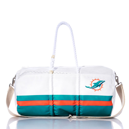 Introducing the Miami Dolphins Duffel by Sea Bags: a recycled sail cloth bag featuring a white design with teal and orange stripes, the Miami Dolphins logo on the side, rope handle, shoulder strap, and a reflective surface beneath—crafted for durability and standout style. by Sea Bags