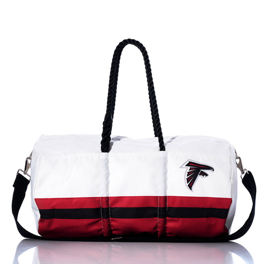 The Atlanta Falcons Duffel by Sea Bags is crafted from recycled sail cloth in white and red, featuring black handles, a shoulder strap, and an NFL logo on the side. It’s shown against a white background. by Sea Bags