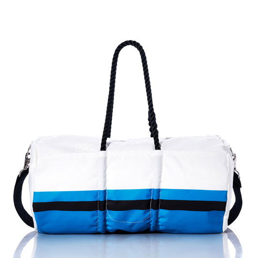 The Sea Bags Carolina Panthers Duffel features black handles and distinctive blue and black horizontal stripes near the bottom, crafted from recycled sail cloth and displayed on a reflective surface—a perfect unique NFL duffel for any Panthers fan. by Sea Bags