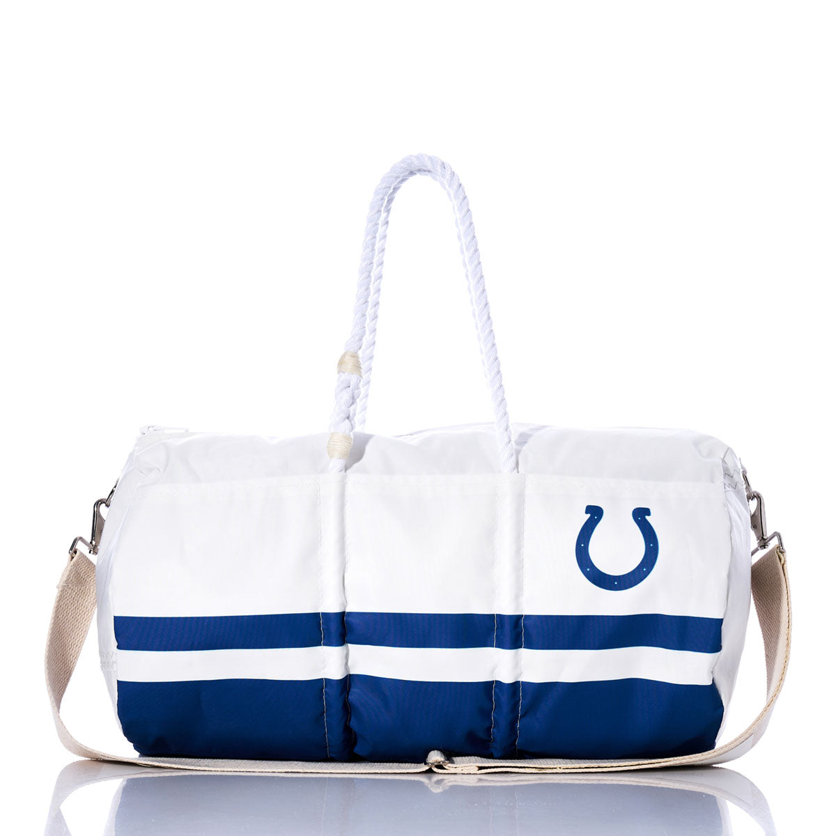 The Sea Bags Indianapolis Colts Duffel, made from recycled sail cloth, features white and blue panels with rope handles, a tan shoulder strap, the NFL logo, and a prominent Colts horseshoe emblem on the side—shown here on a reflective surface. by Sea Bags