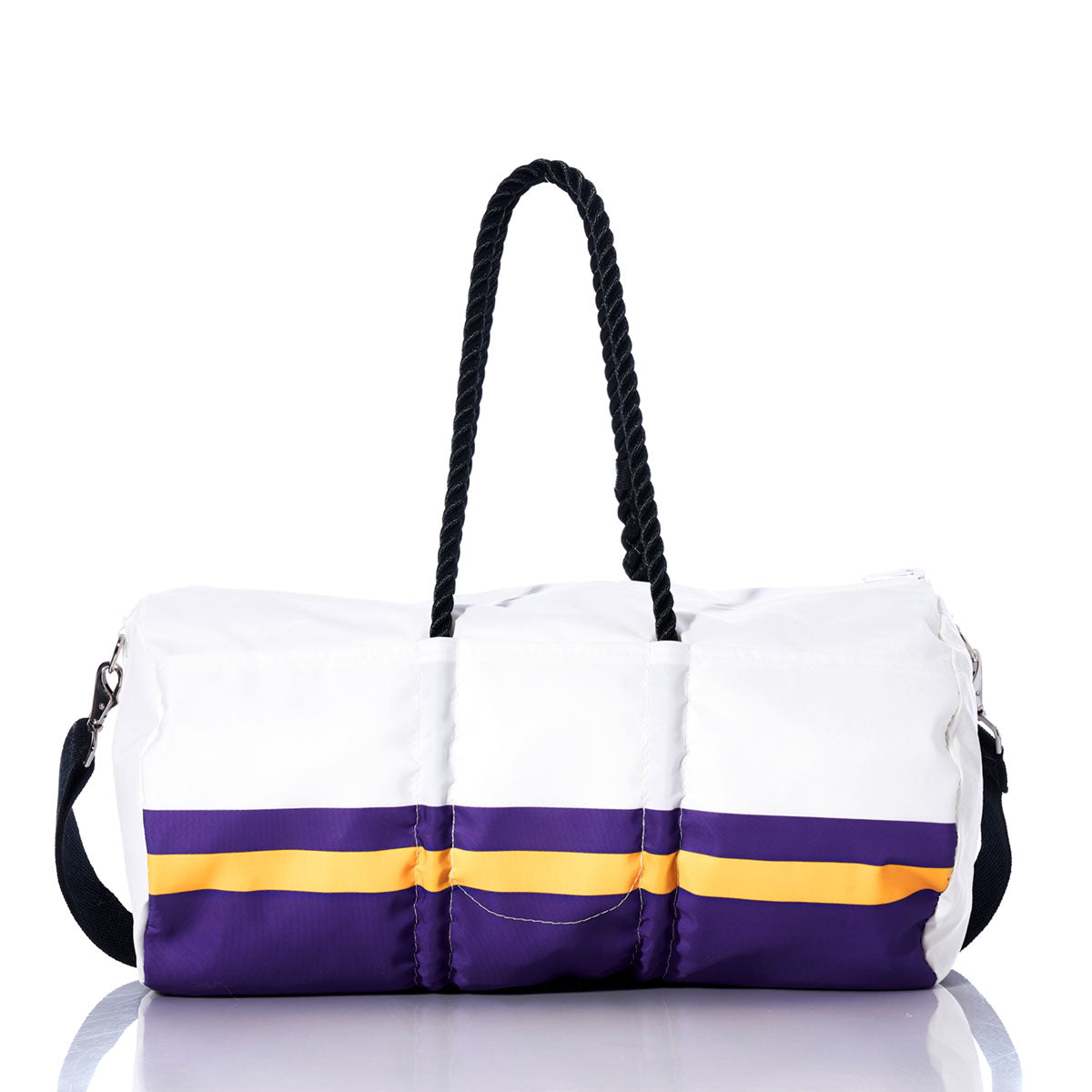 The Sea Bags Minnesota Vikings Duffel, crafted from recycled sail cloth, features purple and yellow stripes inspired by a classic Vikings bag. It is designed with black rope handles and a black adjustable shoulder strap, and is shown on a reflective surface. by Sea Bags