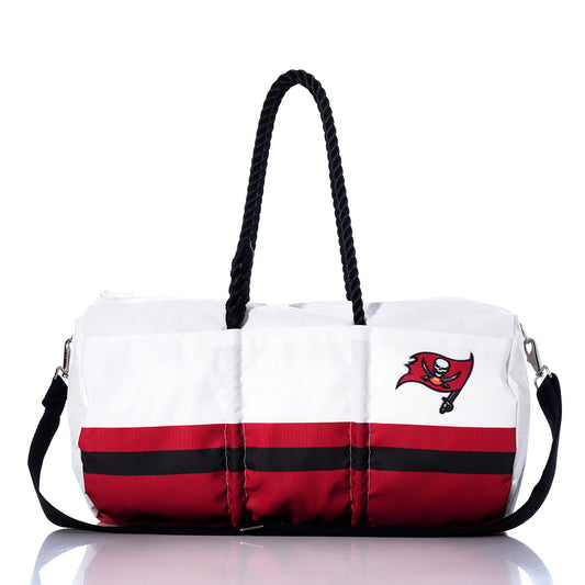 The Sea Bags Tampa Bay Buccaneers Duffel features an officially licensed NFL design in white and red, with black handles, a black shoulder strap, and a bold Buccaneers logo on the side—making it the perfect bag for any fan eager to show off their team pride in style. by Sea Bags