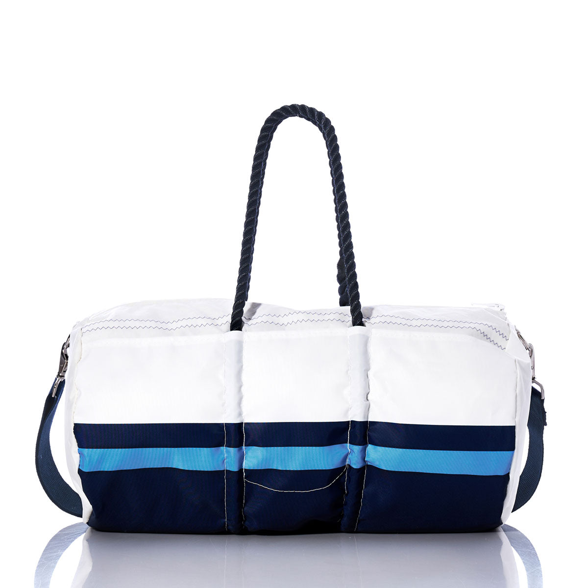 The Tennessee Titans Duffel by Sea Bags is crafted from recycled sail cloth in white and navy blue, featuring a light blue stripe, navy rope handles, and a shoulder strap. The bag is displayed on a reflective surface against a white background. by Sea Bags