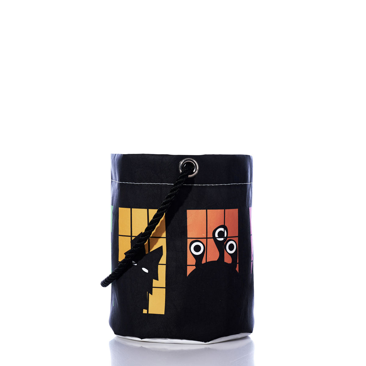 The Monster Party Bucket Bag by Sea Bags is a black cylindrical bag handcrafted from recycled sails, featuring a colorful geometric animal face design, white base, metal eyelet, and a black rope handle—perfect as an eco-friendly Halloween party accessory—photographed on a white background.