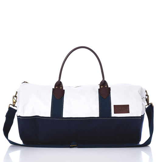 The Chebeague Duffel by Sea Bags—a two-tone bag crafted from recycled sail, featuring a white top, navy bottom, premium leather handles, and a detachable shoulder strap—is displayed against a white background. by Sea Bags