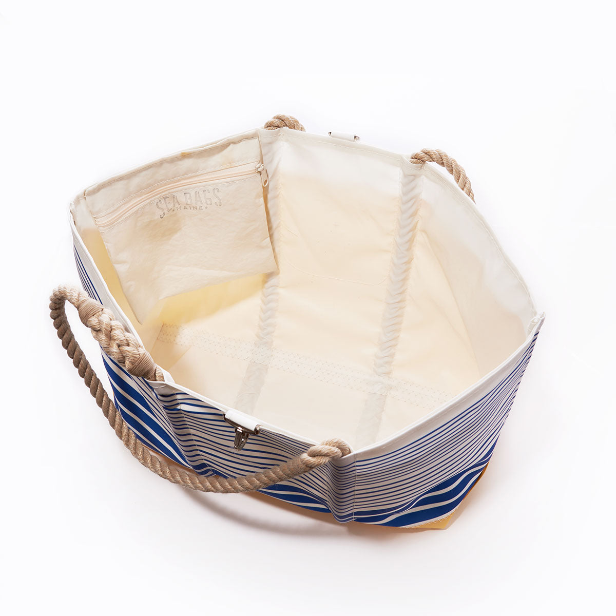 The Sea Bags Blue Stripe Ogunquit Beach Tote features an open design with rope handles, a roomy cream-colored interior, and a zippered inner pocket—expertly crafted from recycled sail cloth for the ideal beach bag. by Sea Bags