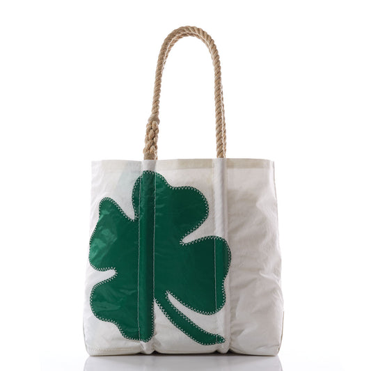 The Sea Bags Four Leaf Clover Medium Tote, made from recycled sail cloth, features sturdy rope handles and a bold green four-leaf clover stitched on the front. Shown against a white background, this festive and eco-friendly accessory is perfect for celebrating St. Patricks Day. by Sea Bags