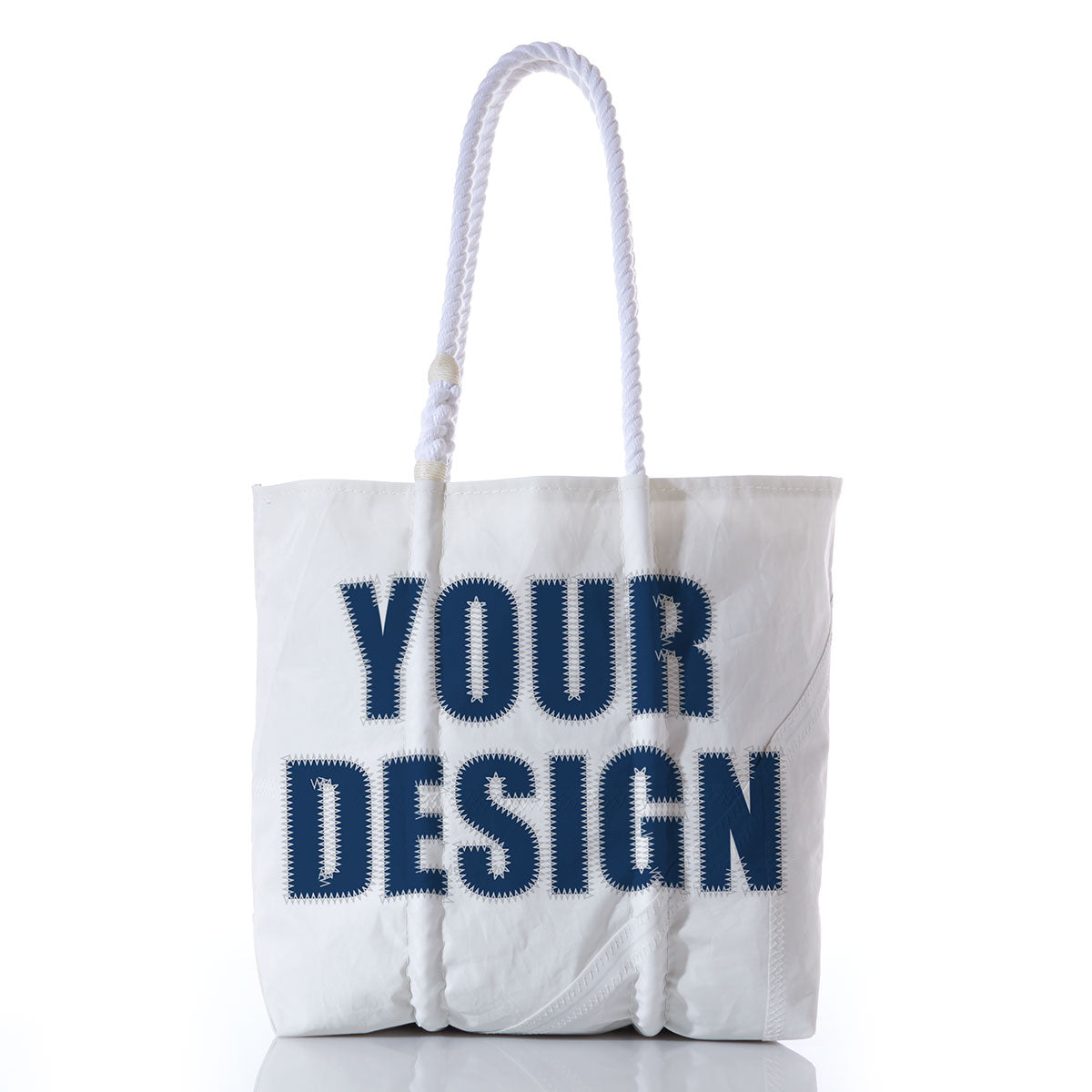 Introducing the Sea Bags Custom Design Medium Tote, a white tote bag expertly crafted from a reclaimed sail and finished with thick rope handles. This unique bag showcases YOUR DESIGN in large, bold navy blue letters on the front against a clean white background. by Sea Bags