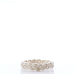A braided natural rope, the Nantucket Knotworks Bracelet by Nantucket Knotworks, is arranged in a circular shape and sits on a white reflective surface with a plain white background. by Sea Bags