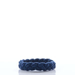 A single Nantucket Knotworks Bracelet in navy, by Nantucket Knotworks, is displayed on a white background with a clear reflection below it. by Sea Bags