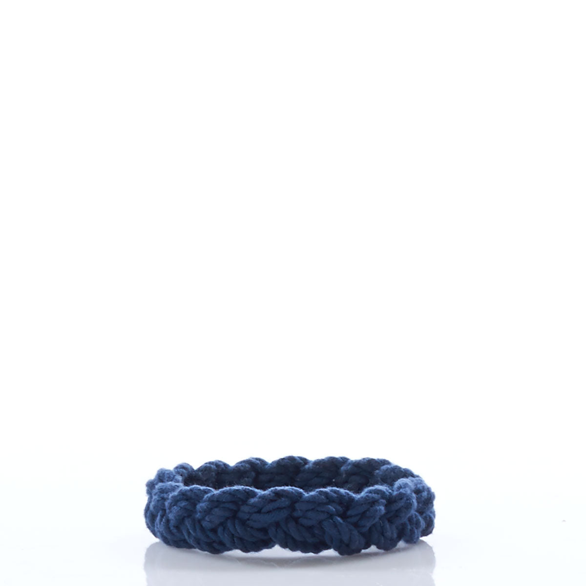 A single Nantucket Knotworks Bracelet in navy, by Nantucket Knotworks, is displayed on a white background with a clear reflection below it. by Sea Bags
