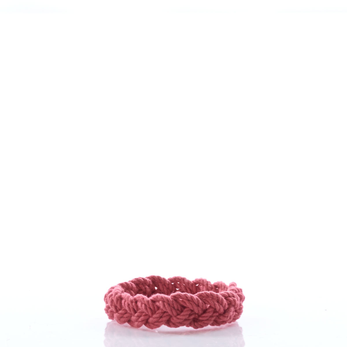 A red braided bracelet from Nantucket Knotworks, inspired by the classic Nantucket Rope Bracelet, is displayed on a white background. by Sea Bags