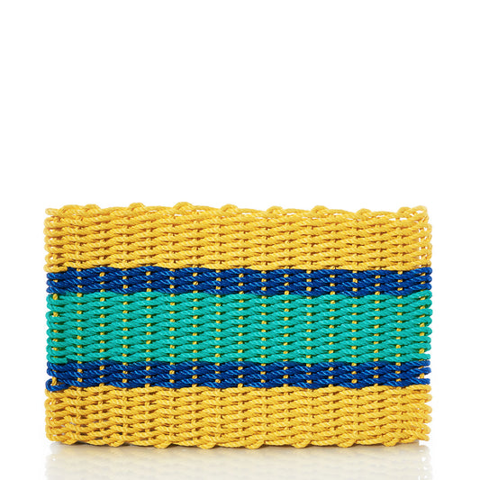 A rectangular woven clutch inspired by the Fisherman Rope Mat - Blue  Yellow Stripe from Custom Cordage / DBA Maine Rope Mats, featuring yellow edges, a bold central green stripe, and a narrower blue stripe reminiscent of the mat’s distinctive blue and yellow pattern, displayed against a white background. by Sea Bags