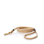 The Maine Rope Dog Leash - Maine Bicentennial by Custom Cordage DBA Maine Rope Mats features beige yacht braid and a brass clip, looped neatly on a white background—a stylish, nautical dog leash handmade in Maine. by Sea Bags