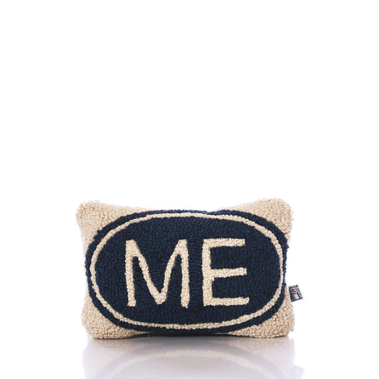 The Chandler 4 Corners Wool Hand-hooked Maine Pillow features a rectangular cream design accented with a navy blue oval and the word ME in bold cream letters centered on the front, bringing a touch of Maine charm to any space. by Sea Bags