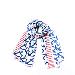 Batela USA Incs Anchor Pop Scarf—crafted from white nautical cotton with blue anchor patterns and red stripes—is shown on a white background, making it the perfect stylish accessory for your Sea Bag. by Sea Bags