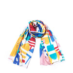 The Downeast Buoys Scarf by Batela USA Inc is a vibrant, abstract-patterned cotton accessory, neatly rolled and displayed on a white background—a chic nautical addition perfect for any wardrobe. by Sea Bags