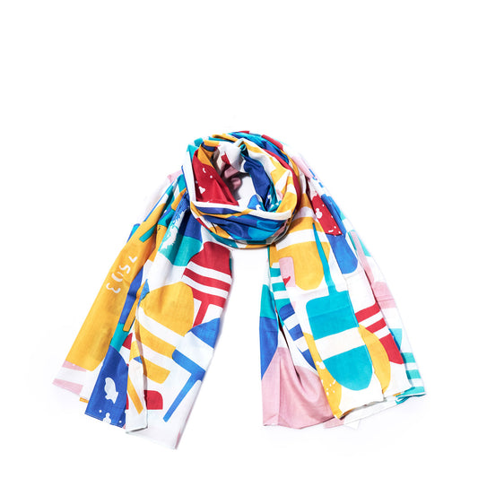 The Downeast Buoys Scarf by Batela USA Inc is a vibrant, abstract-patterned cotton accessory, neatly rolled and displayed on a white background—a chic nautical addition perfect for any wardrobe. by Sea Bags