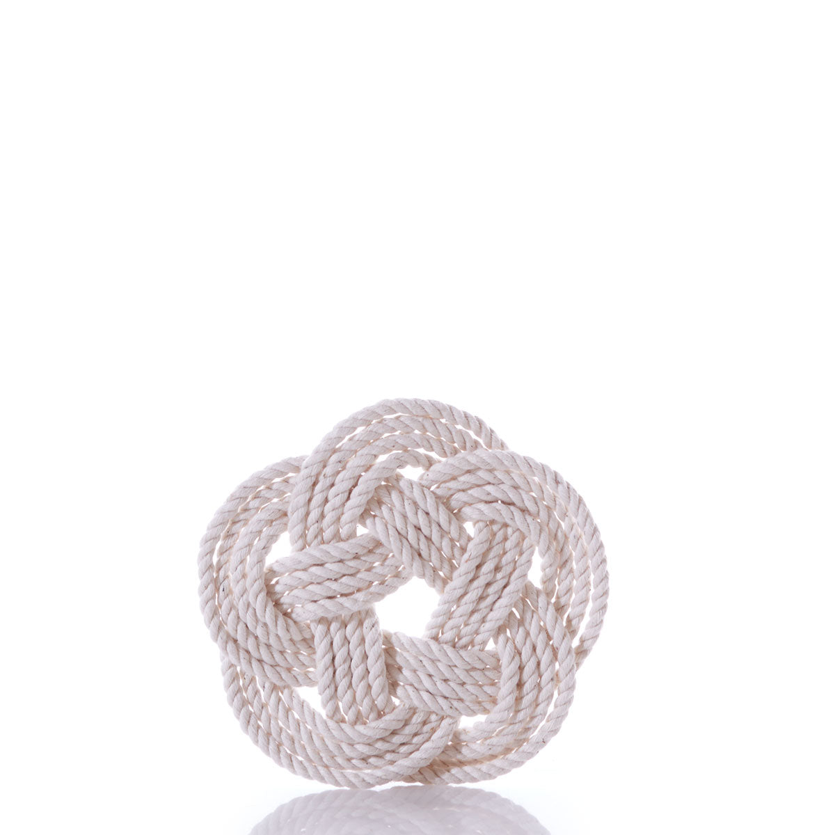 A natural-colored rope, intricately tied into a circular nautical sailor knot with a detailed pattern, is displayed on a white reflective surface against a plain white background, reminiscent of Nautical Sailor Knot Coasters-Natural.