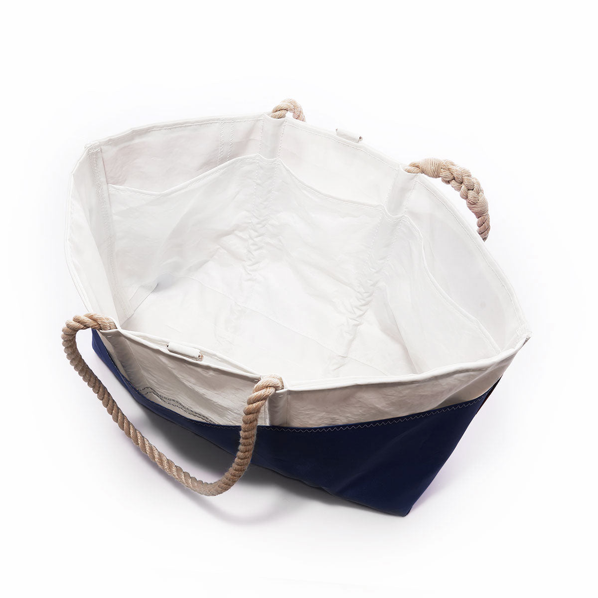 Custom Design Ogunquit Beach Tote by Sea Bags featuring a spacious, open design with a white interior, navy blue bottom, and tan rope handles, viewed from above at an angle. by Sea Bags