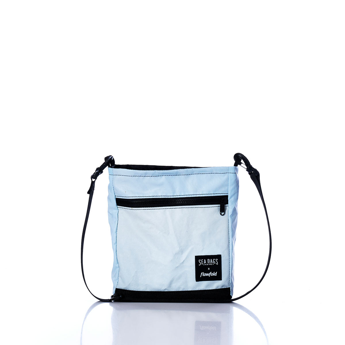 Vintage Light Blue Small Voyager Crew Crossbody by Sea Bags, featuring a black adjustable strap, front zippered pocket, and a SEA BAGS logo patch, crafted from recycled sail cloth for a durable and sustainable design, displayed on a white background. by Sea Bags